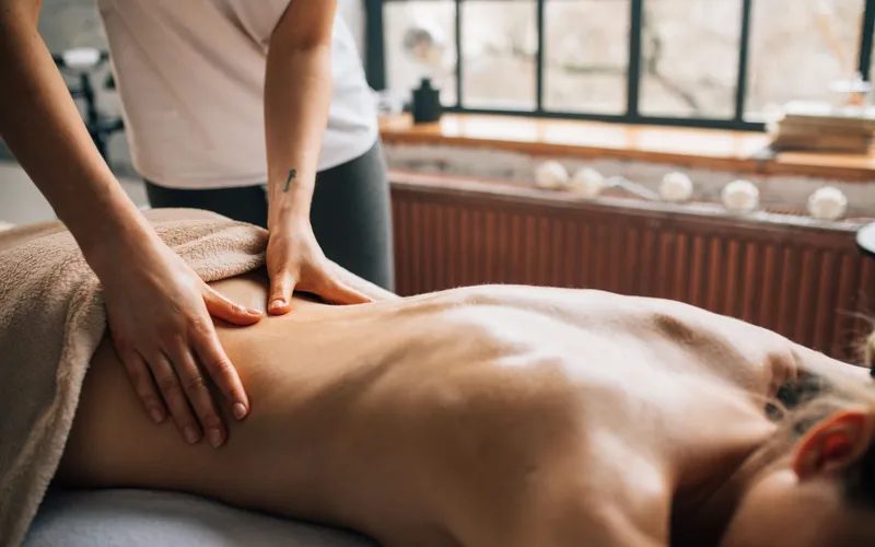 Therapeut geeft een ontspannende massage in een rustige behandelkamer